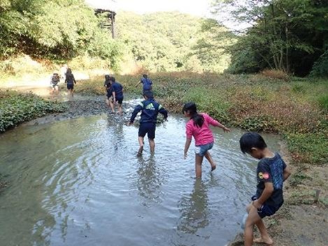 地元の小学校の児童が裸足でどろんこの中であそぶ